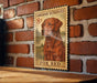 A wooden frame with a vintage-style illustration of a Labrador Retriever dog, mounted on a brick wall.