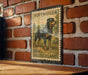 A metal sign featuring a rottweiler dog, with the text "Rottweiler Deutschland" printed on it, mounted on a brick wall.
