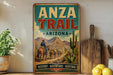 a vintage-style sign for the Anza Trail in Arizona, with a cowboy on horseback and a desert landscape in the background.