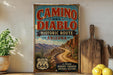 a vintage-style sign for the Camino del Diablo Historic Route in Arizona, with a desert landscape and a road sign for the route.