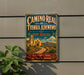 A vintage-style metal sign for the Camino Real de Tierra Adentro trail in New Mexico, featuring a desert landscape with a castle and a road.