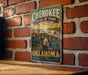 A vintage-style metal sign with the title "CHEROKEE TRAIL OF TEARS" displayed on a brick wall.