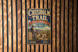 A vintage-style metal sign for the Chisholm Trail in Oklahoma, featuring a cowboy on horseback and the text "OKLAHOMA" and "CHISHOLM TRAIL" prominently displayed.