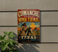 a vintage metal sign with a cowboy on horseback, advertising the Comanche War Trail in Texas.