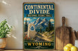 A vintage-style metal sign for the Continental Divide National Scenic Trail in Wyoming, featuring a mountain landscape and a trail marker.