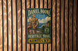 A vintage-style metal sign for the Daniel Boone Heritage Trail in Kentucky, featuring an illustration of a man in traditional clothing and a mountainous landscape.