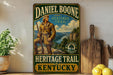 A vintage-style metal sign for the Daniel Boone Heritage Trail in Kentucky, featuring a depiction of a man in traditional clothing and a rifle.