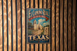A vintage-style metal sign for El Camino Real, the Royal Road in Texas, featuring a church and a road.