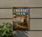 A vintage metal sign for the Historic Emigrant Trail in California, featuring an illustration of a covered wagon and mountains in the background.