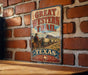 A vintage-style metal sign with the text "GREAT WESTERN TRAIL TEXAS" is displayed on a brick wall.