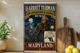 A vintage-style poster of Harriet Tubman, the Underground Railroad, and a map of Maryland, with a wooden paddle and lemons on a shelf in the foreground.