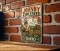 A vintage-style sign for the Johnny Appleseed Heritage Trail in Ohio, featuring an illustration of a man holding an apple and a sign that says "Walk the Legend, Share the Heritage".