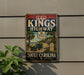 A vintage sign for Kings Highway, featuring a car and palm trees, is displayed on a wall next to a plant.