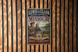 A vintage-style metal sign for the Lewis & Clark National Historic Trail in Missouri, featuring two men in historical attire and a scenic landscape.