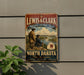 A vintage-style metal sign for the Lewis & Clark National Historic Trail, featuring a historical illustration of two men on a trail in North Dakota.