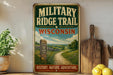 A vintage-style metal sign for the "MILITARY RIDGE TRAIL" in Wisconsin, featuring a scenic landscape with a dirt path and a wooden signpost.