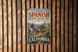 A vintage metal sign for the Old Spanish National Historic Trail in California, featuring an illustration of a cowboy on horseback and a desert landscape.