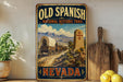 a vintage-style sign for the Old Spanish National Historic Trail in Nevada, with a wagon train depicted on the trail.