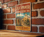 A vintage-style sign for the Old Spanish National Historic Trail in New Mexico, featuring a desert landscape with a church and mountains in the background.