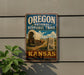 A vintage-style metal sign for the Oregon National Historic Trail in Kansas, featuring an illustration of a covered wagon and a monument.