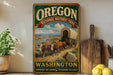 a vintage-style sign for the Oregon National Historic Trail, with a wagon train depicted in the background. The sign is displayed on a shelf next to a wooden cutting board and a potted plant.