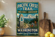 A vintage-style sign for the Pacific Crest Trail Historic Corridor in Washington, featuring a mountain landscape and a trail marker.