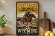 A vintage-style metal sign advertising Pony Express National Historic Trail, featuring a cowboy riding a horse and the text "The mail must go through Wyoming".
