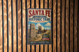 a vintage-style sign for the Santa Fe National Historic Trail in Kansas, with a wagon and a monument depicted on the sign.