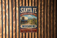 A vintage-style sign for the Santa Fe National Historic Trail in Missouri, featuring an illustration of a wagon and a sign that says "Missouri".