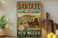 a vintage-style sign for the Santa Fe National Historic Trail in New Mexico, with a wagon train depicted on the sign.