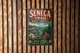 A vintage-style metal sign for the Seneca Trail in West Virginia, featuring a red bird, flowers, and a mountain landscape.