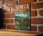 a vintage-style metal sign with the text "SENECA TRAIL WEST VIRGINIA" and a scenic illustration of a mountain landscape with a red cardinal bird.