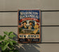 A vintage-style metal sign with the text "Washington-Rochambeau Revolutionary Route New Jersey" and an illustration of two men in military uniforms, likely representing the Revolutionary Route in New Jersey.
