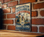 A vintage-style metal sign with the text "WASHINGTON-ROCKAMBEAU REVOLUTIONARY ROUTE" and "RHODE ISLAND" is displayed on a brick wall.
