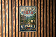 A vintage-style metal sign for Wilderness Road in Virginia, featuring a wagon train and a scenic mountain landscape.