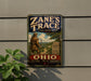 A vintage metal sign for "Zane's Trace" is displayed on a wall, featuring a man walking along a path through a scenic landscape.