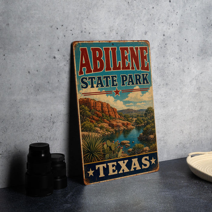 A vintage-style sign for Abilene State Park in Texas, featuring a scenic landscape with a river and mountains.
