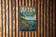 A vintage-style metal sign for Afton State Park in Minnesota, featuring a scenic landscape with a lake, mountains, and a sailboat.