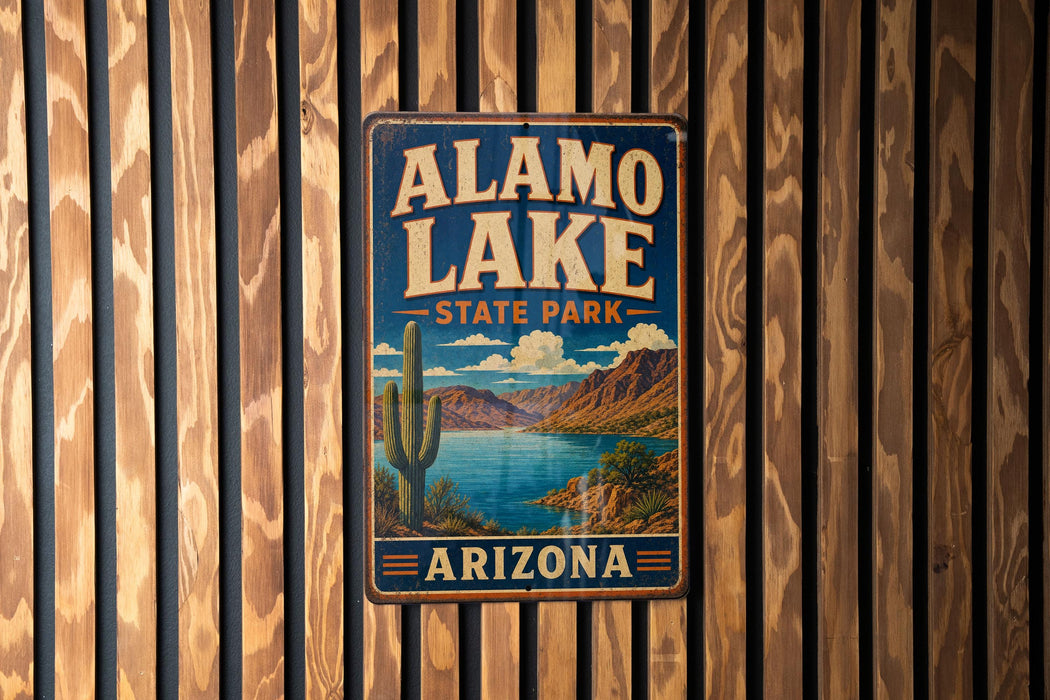 A vintage-style metal sign for Alamo Lake State Park in Arizona, featuring a desert landscape with a cactus and a lake.