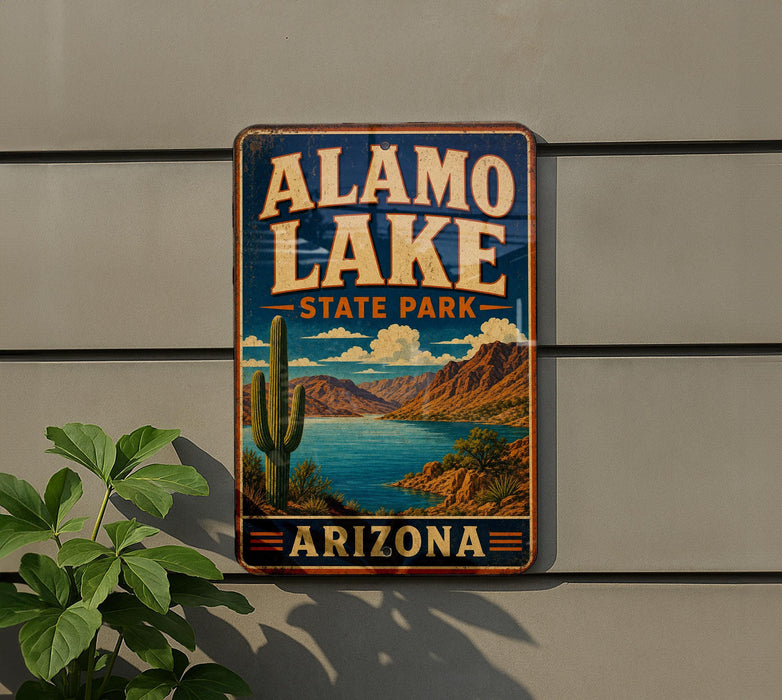 A vintage-style sign for Alamo Lake State Park in Arizona, featuring a desert landscape with a cactus and a lake.