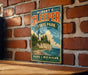 A vintage-style metal sign for Albert E. Sleeper State Park in Michigan, featuring a lighthouse and a scenic landscape.