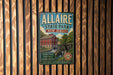 A vintage metal sign for Allaire State Park in New Jersey, featuring a red brick building and a watermill, mounted on a wooden wall.