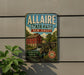A vintage metal sign for Allaire State Park in New Jersey, featuring a red brick building, a watermill, and scenic trails.
