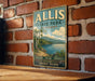 A vintage-style metal sign for Allis State Park in Vermont, featuring a scenic landscape with a lake and mountains.