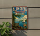 A vintage-style metal sign for Alum Creek State Park in Ohio, featuring a scenic illustration of a lake with a sailboat, surrounded by nature and recreation activities.