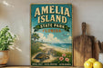 A vintage-style sign for Amelia Island State Park in Florida, featuring a beach scene with a turtle, palm trees, and a wooden board.