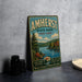 A vintage metal sign for Amherst State Park in New York, featuring a scenic landscape with a lake and pine trees.
