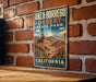 A vintage metal sign for Anza-Borrego Desert State Park in California, featuring a desert landscape with a ram and cactus in the foreground.