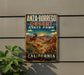 A vintage-style metal sign for Anza-Borrego Desert State Park in California, featuring a desert landscape with a ram and cacti.