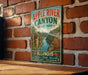 A vintage-style metal sign for Apple River Canyon State Park in Illinois, featuring a scenic illustration of the canyon and its surroundings.